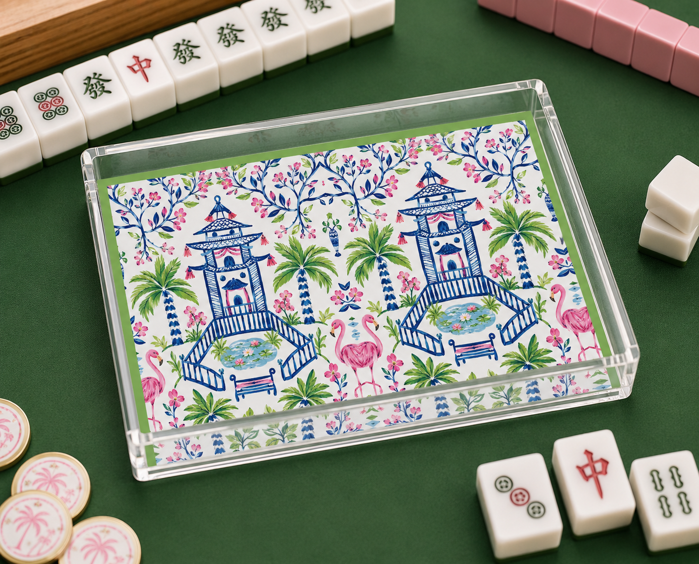 Decorative box with floral and pagoda design on a green surface with Mahjong tiles.
