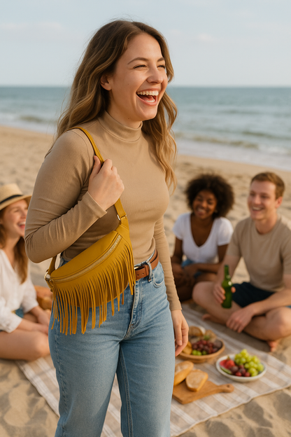 Woman laughing on a beach with friends and a picnic setup