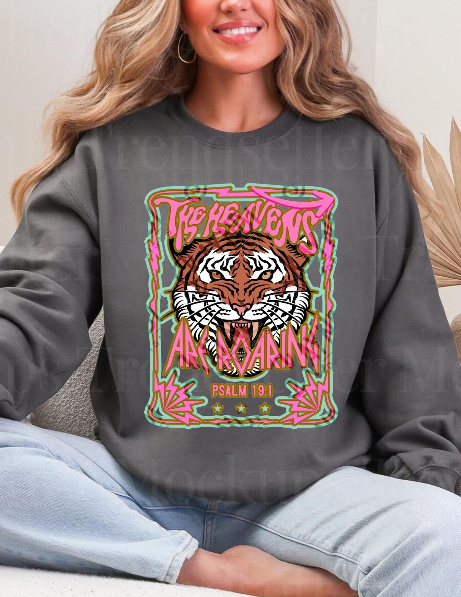 Person wearing a dark gray sweatshirt with a colorful tiger graphic and text.